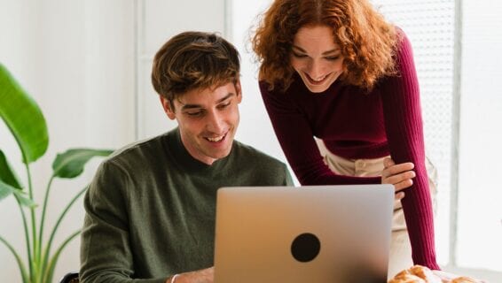 Ein Mann und eine Frau arbeiten vor einem Laptop