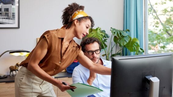Eine Frau und ein Mann besprechen Informationen am Computer.