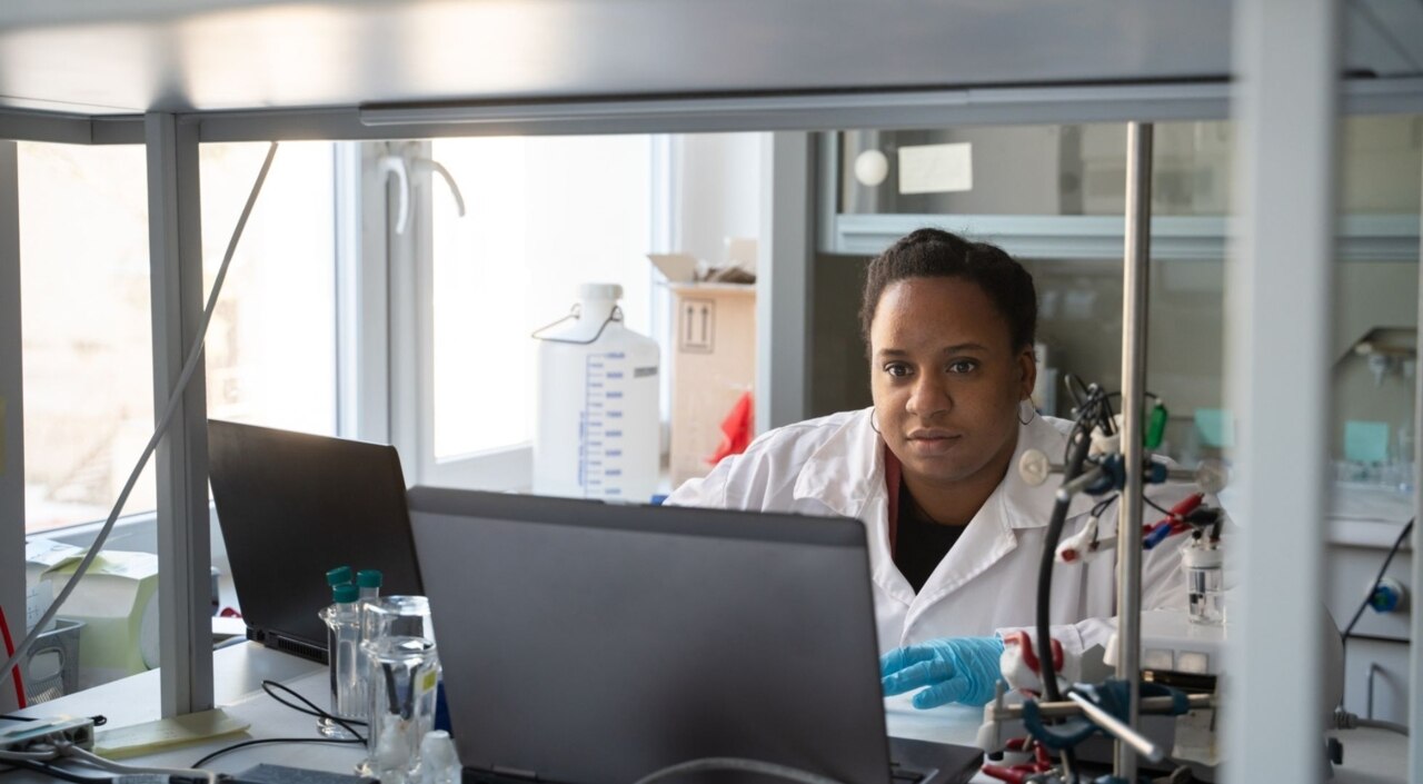 Frau sitzt vor einem Laptop im Labor
