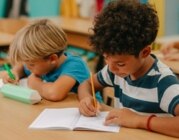 Kinder schreiben in der Schule etwas in ihre Hefte