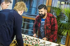 Zwei Mitarbeiter unterhalten sich vor dem PC