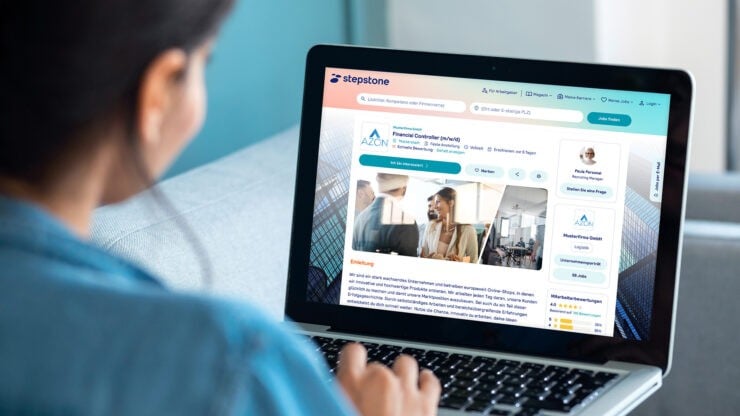 Eine Frau arbeitet vor einem Laptop, auf dem eine Stepstone Stellenanzeige zu sehen ist