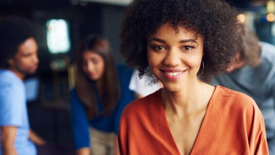 Eine junge Frau lächelt frontal in die Kamera