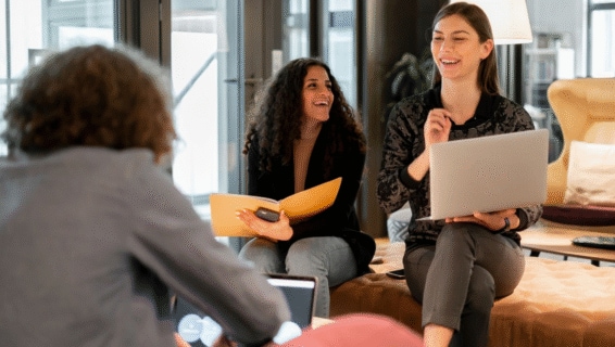 Drei Kolleg*innen sitzen sich gegenüber und unterhalten sich