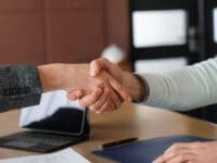 Ein Handschlag über einem Schreibtisch