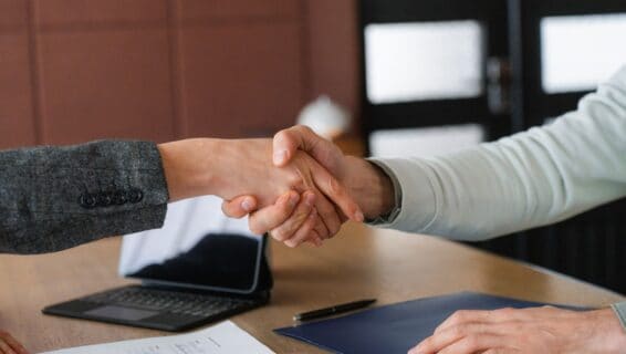 Ein Handschlag über einem Schreibtisch